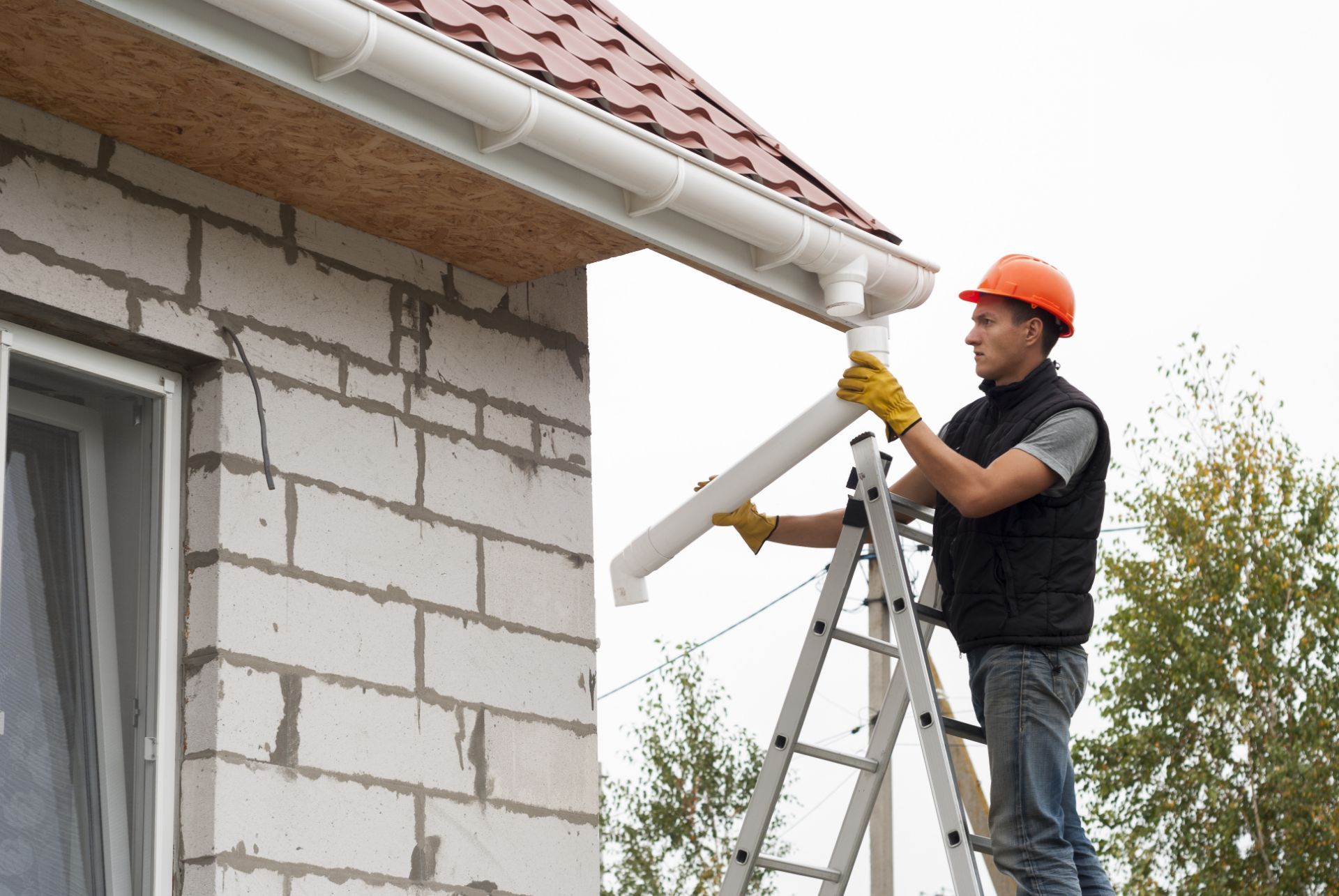 Worker affixing new white gutters
