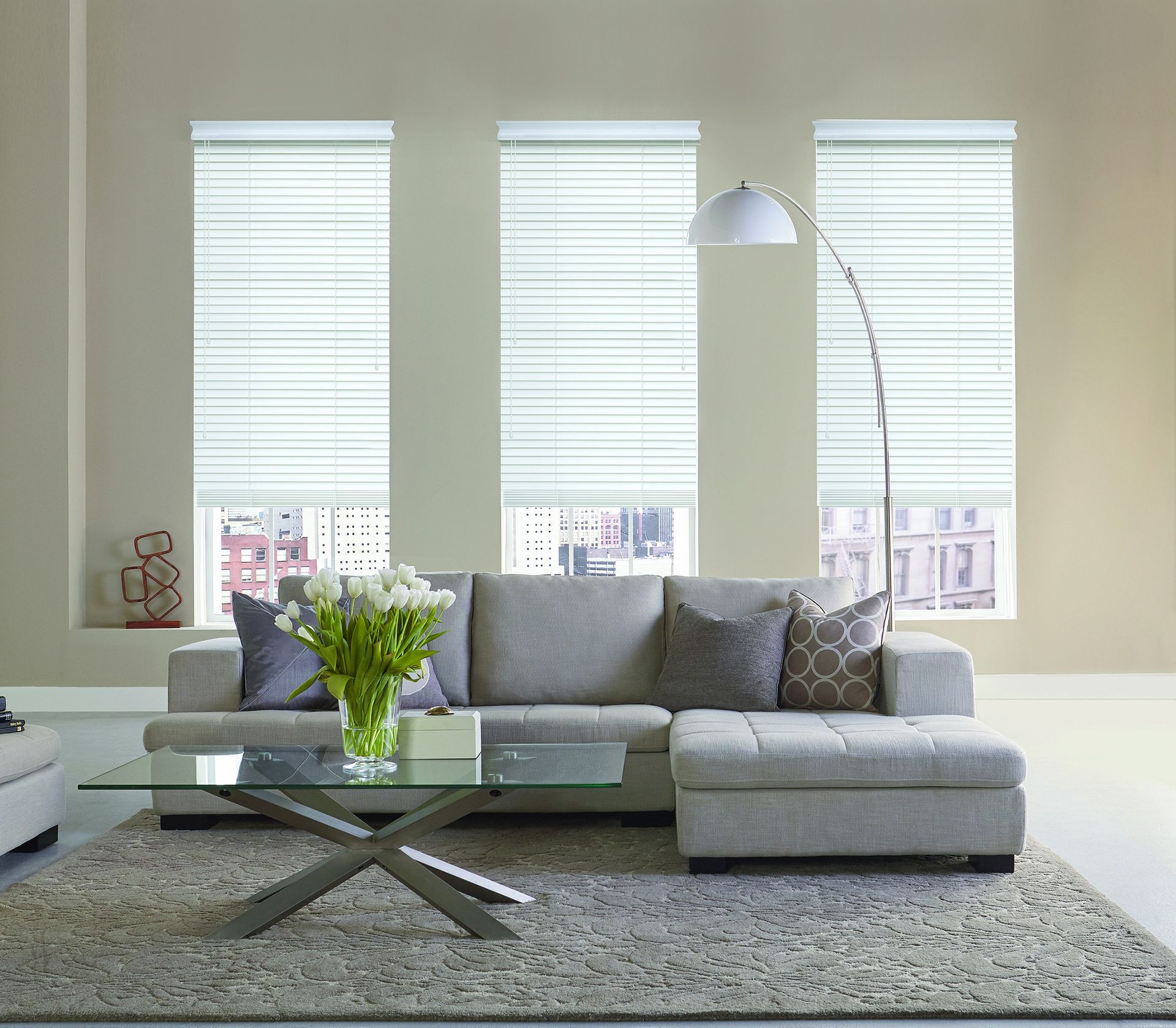 Close-up of a light-colored roller shade covering a window, with a 