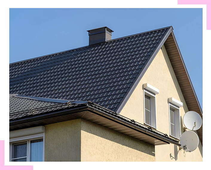 A house with a black roof and satellite dishes on the side.