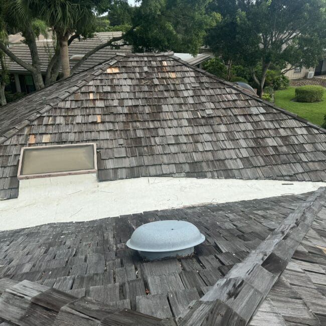 A wooden roof with a white roof vent on it