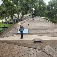 A man is standing on the roof of a house.