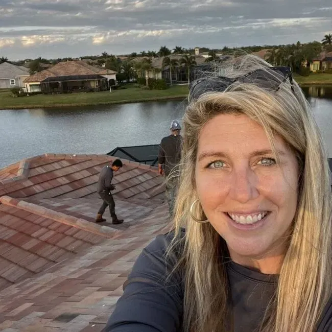 A woman is taking a selfie on the roof of a house