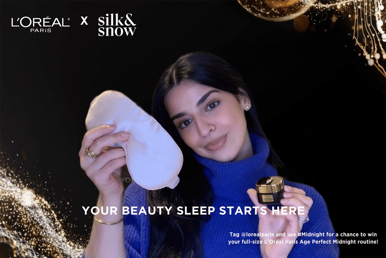 Woman holding eye mask and cream jar. Black background with gold accents, L'Oréal ad.