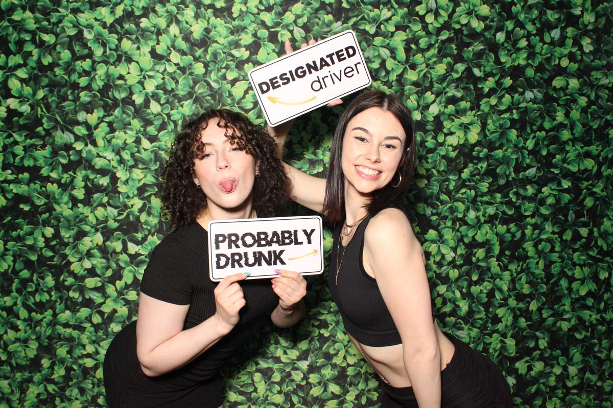 Two women pose with signs: 