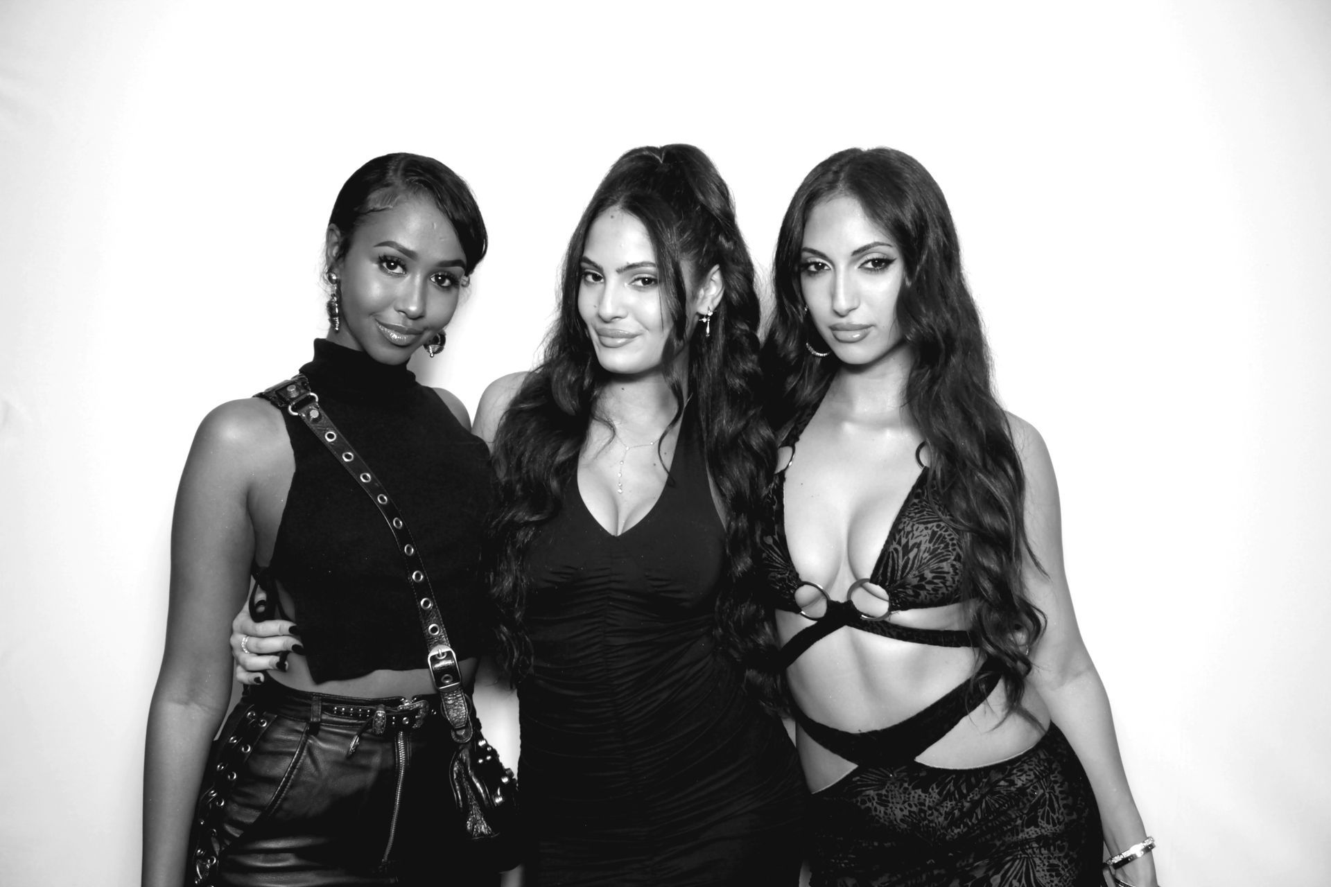 Three women in black outfits posing for a photo.