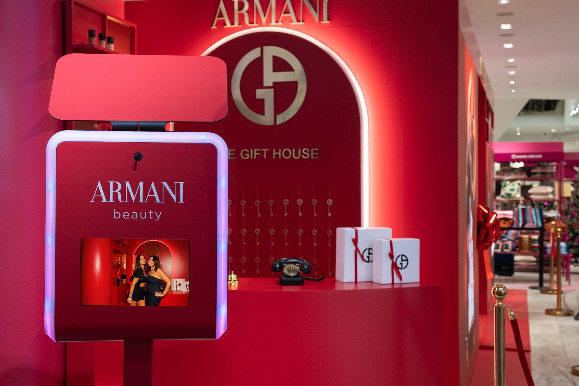 Armani Beauty gift house display with photo booth in red. Includes wrapped gift boxes and arched sign.