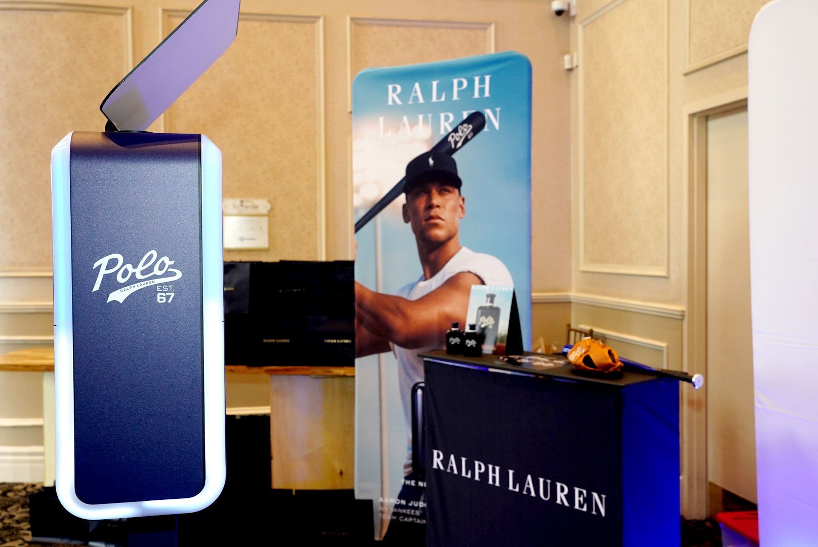 Photo booth at a Ralph Lauren event with a Polo 67 logo and a man holding a lacrosse stick.