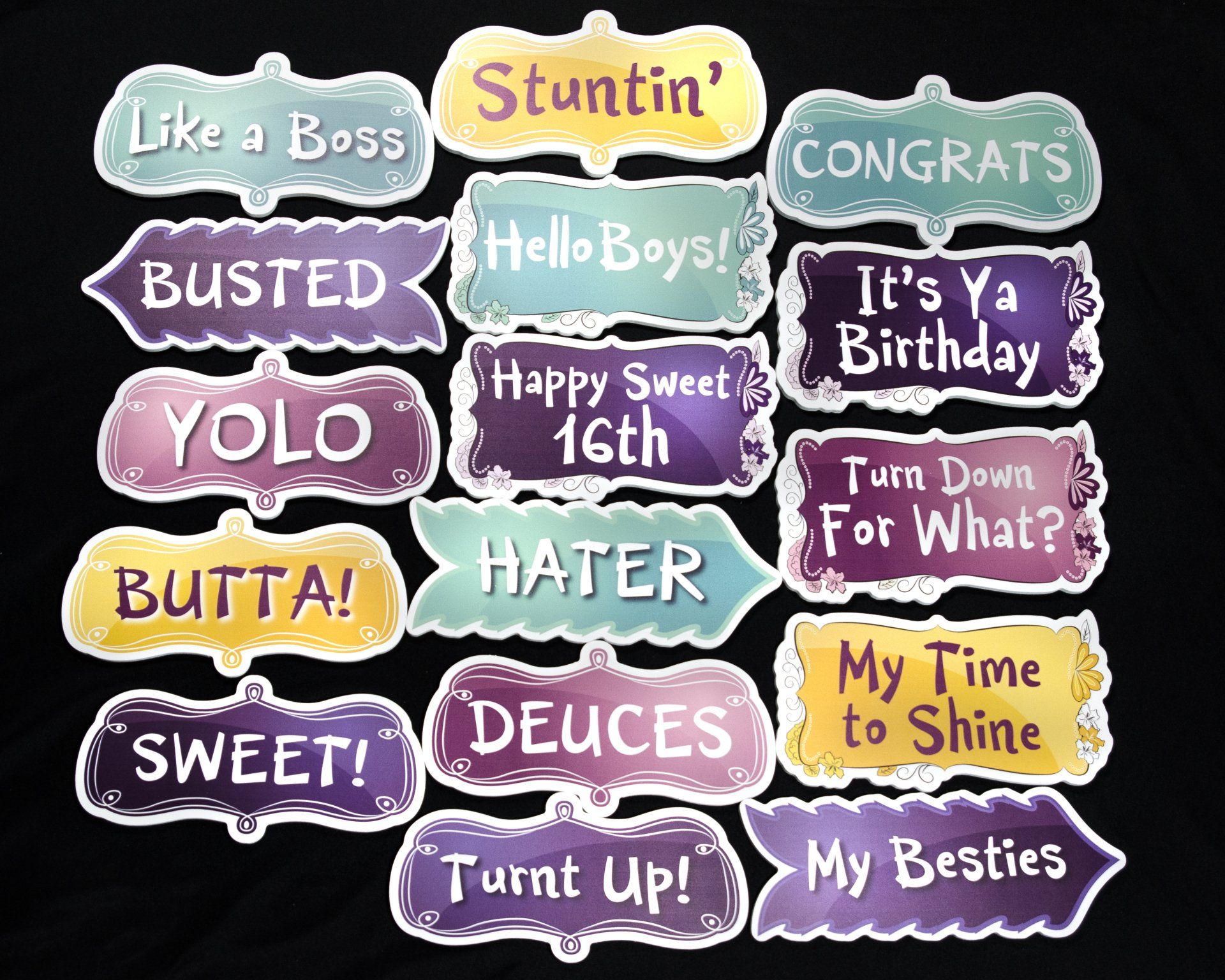 Photo booth props with various celebratory phrases in purple, gold, and blue colors.
