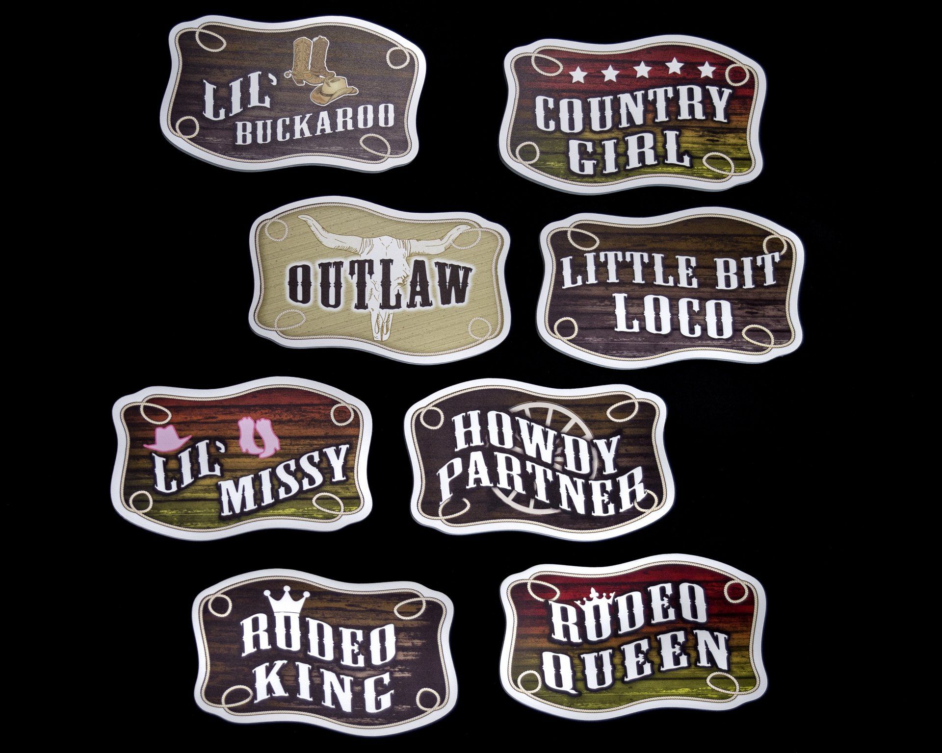 Collection of western-themed belt buckles, each with a different phrase, on a black background.