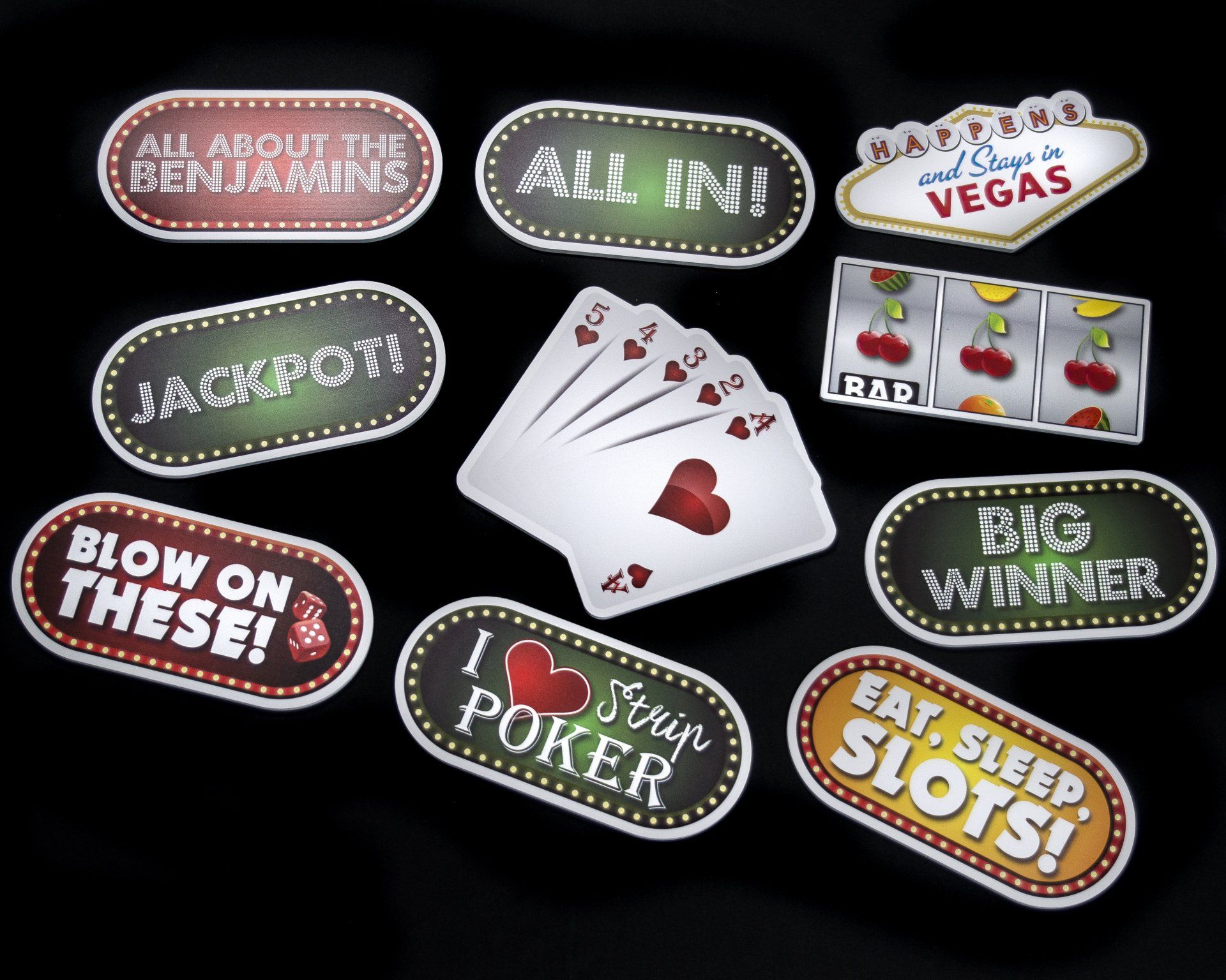 Casino-themed signs and playing cards on a black surface. Signs read 