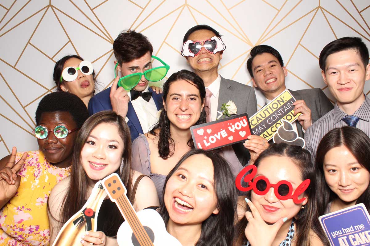 Group of people smiling with photo booth props.