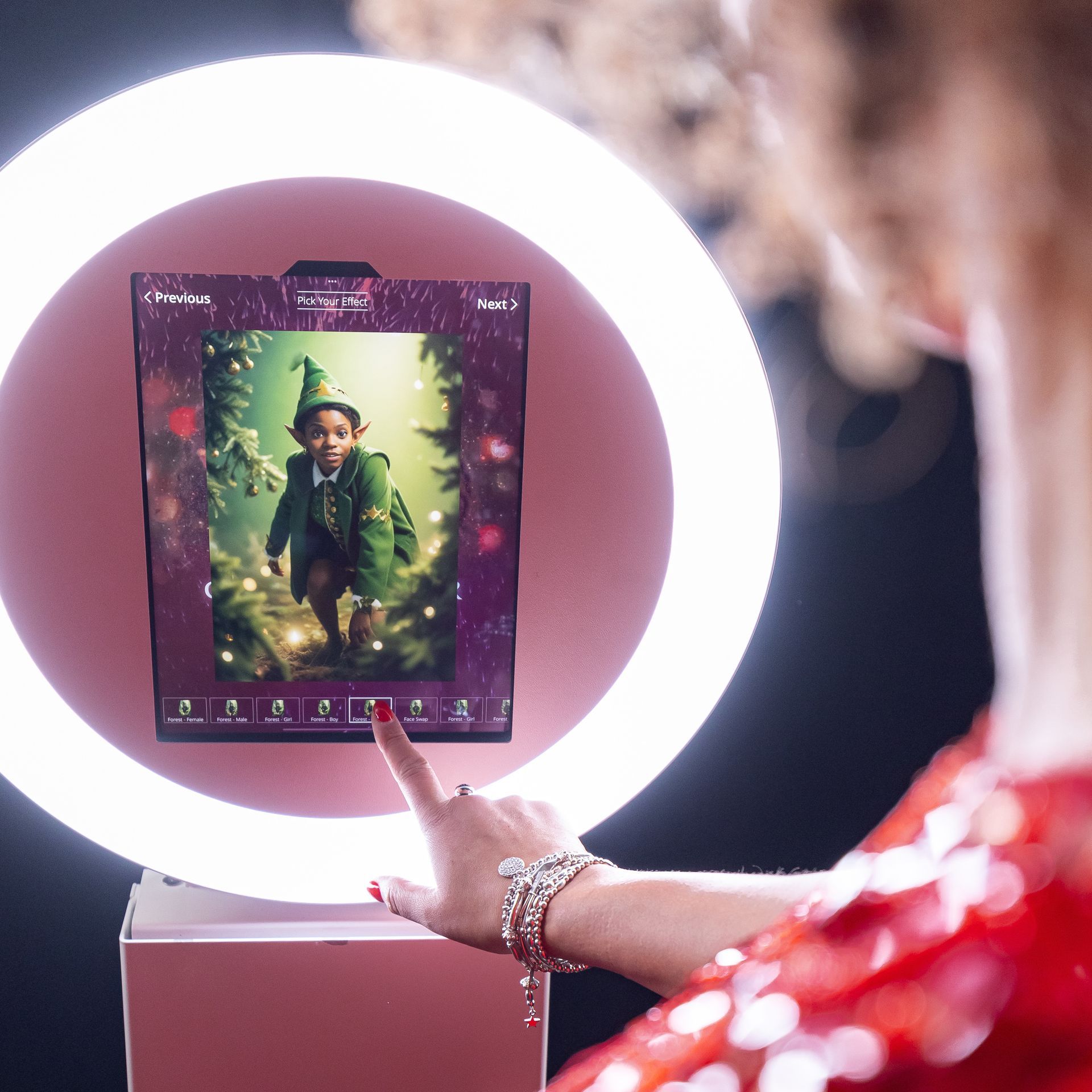 Person using a ring light photo booth displaying a boy in an elf costume.