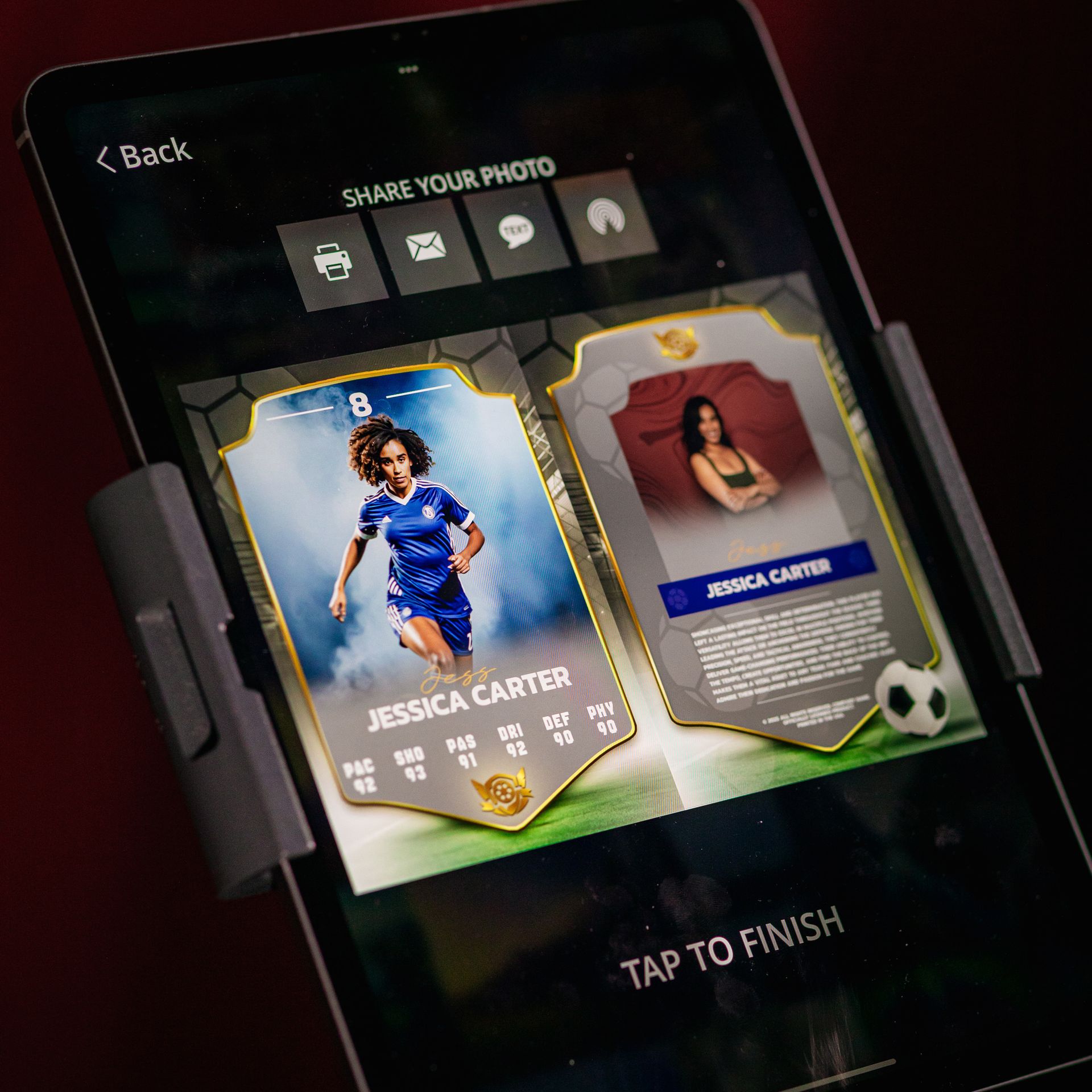 Tablet displaying soccer player trading cards, one with a photo of a woman in a blue soccer uniform, another with a headshot.
