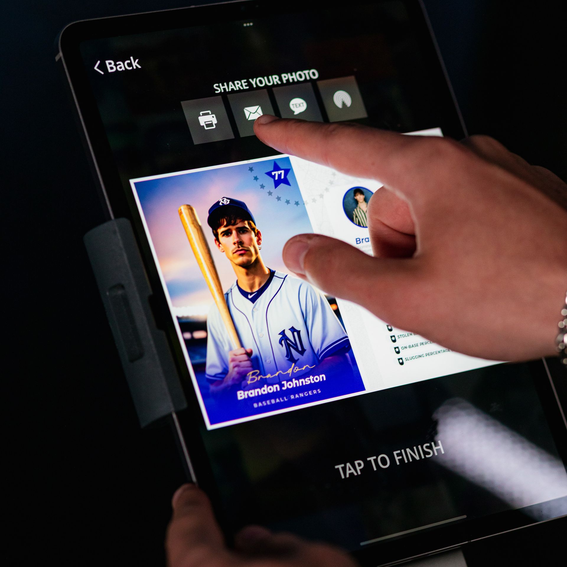 Person sharing a baseball card photo on a tablet. Screen shows sharing options: print, email, and share.