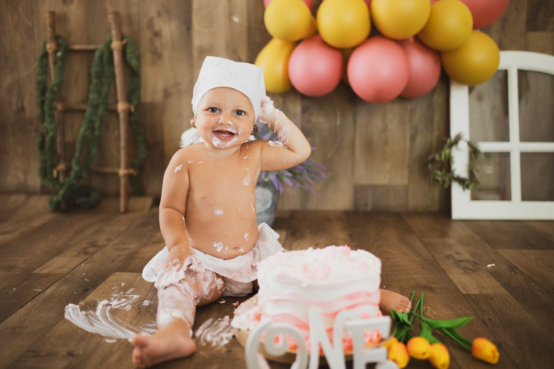 Un bambino sorride, ricoperto di torta, durante un servizio fotografico