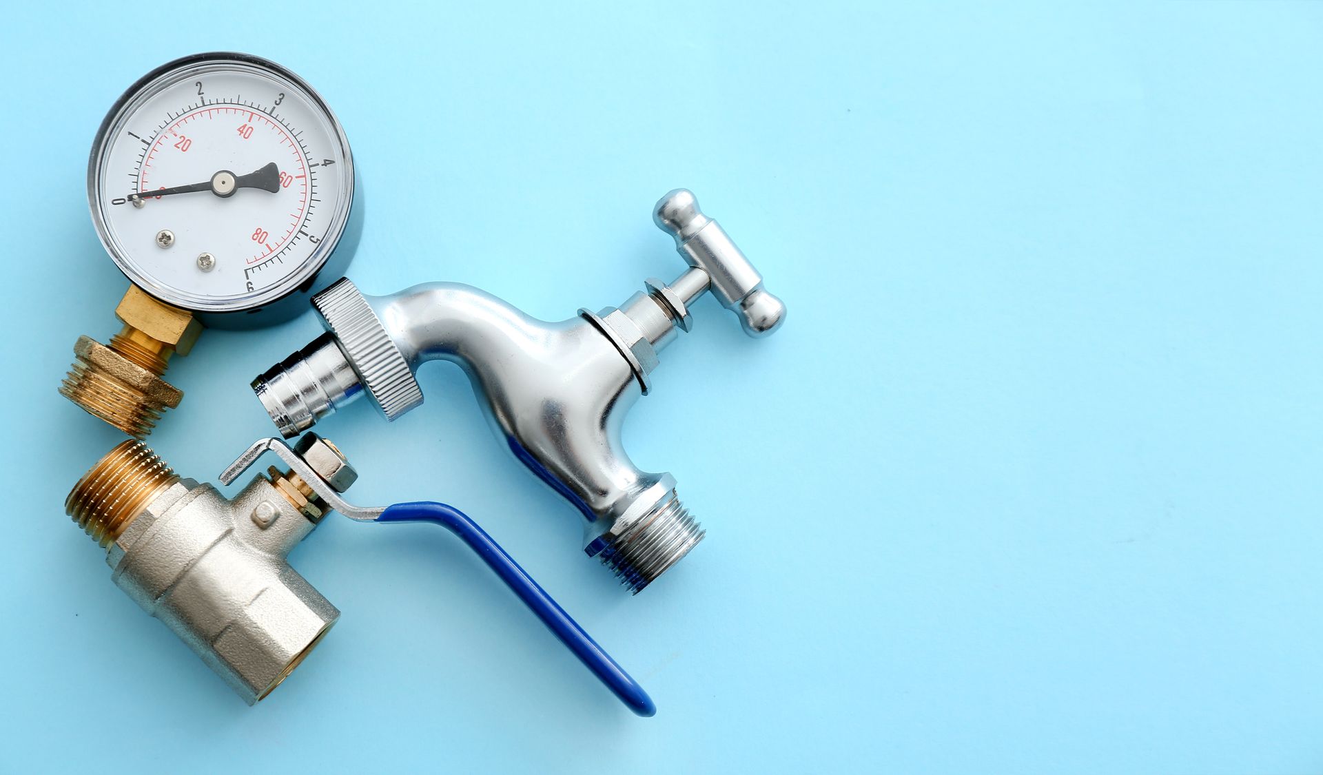 Silver faucet with pressure gauge and valve on a light blue background Silver faucet with pressure gauge and valve on a light blue background