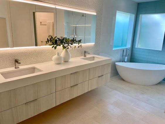 Modern bathroom with long vanity, large mirror, and freestanding soaking tub