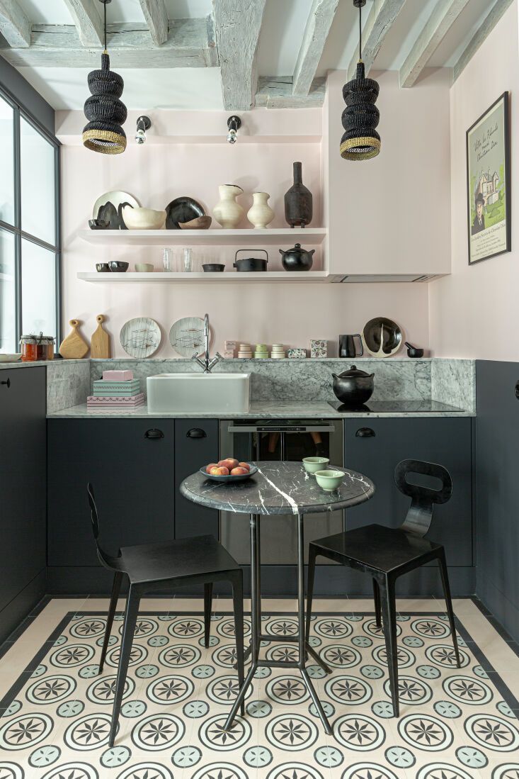 Stylish kitchen nook with black cabinets, patterned tile floor, and small round table with chairs