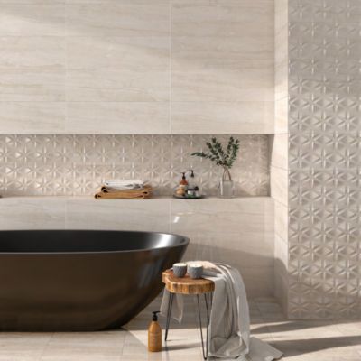 Modern beige bathroom with a black freestanding tub, stool with towel, and patterned tile wall