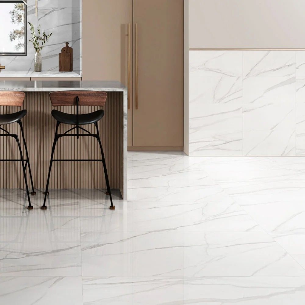 Modern kitchen with white marble floor, tan cabinetry, and black bar stools by the island