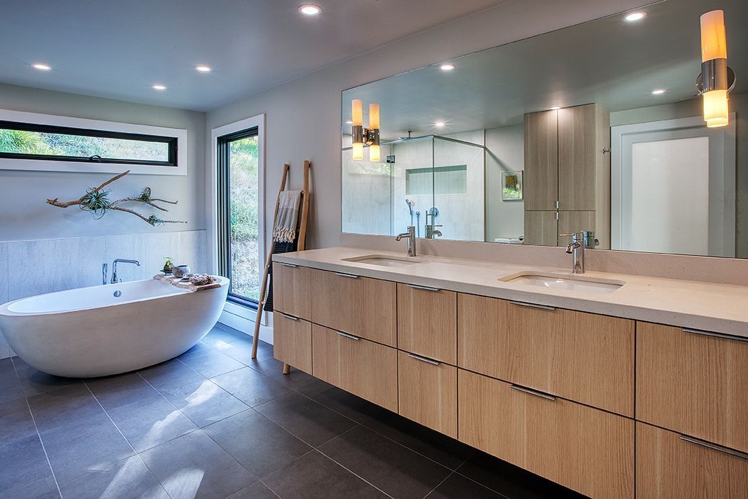 Spacious bathroom with soaking tub, double vanity, large mirror, and patterned curtains