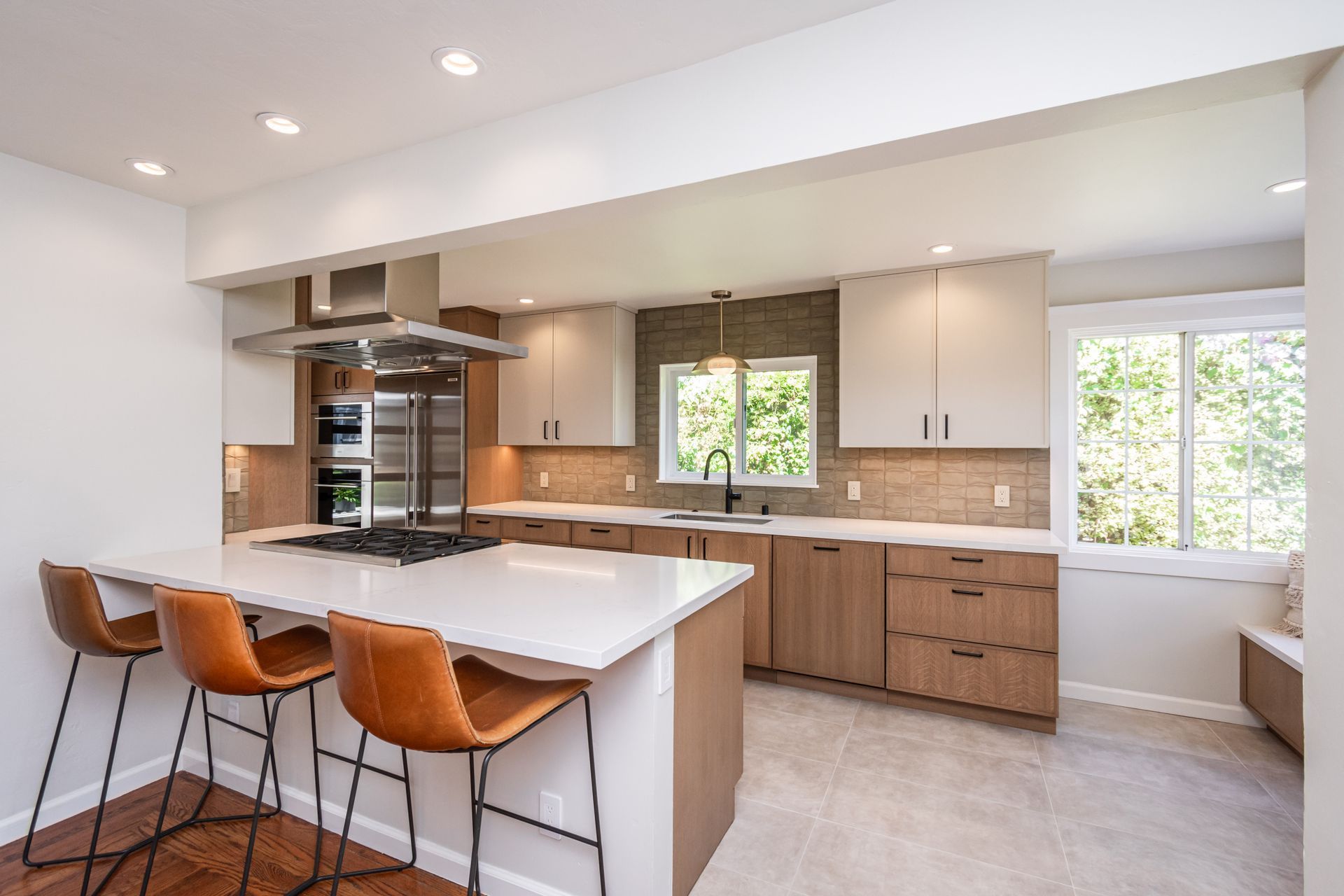 Modern minimalist kitchen with wood cabinets, white island, and blue under-cabinet lighting