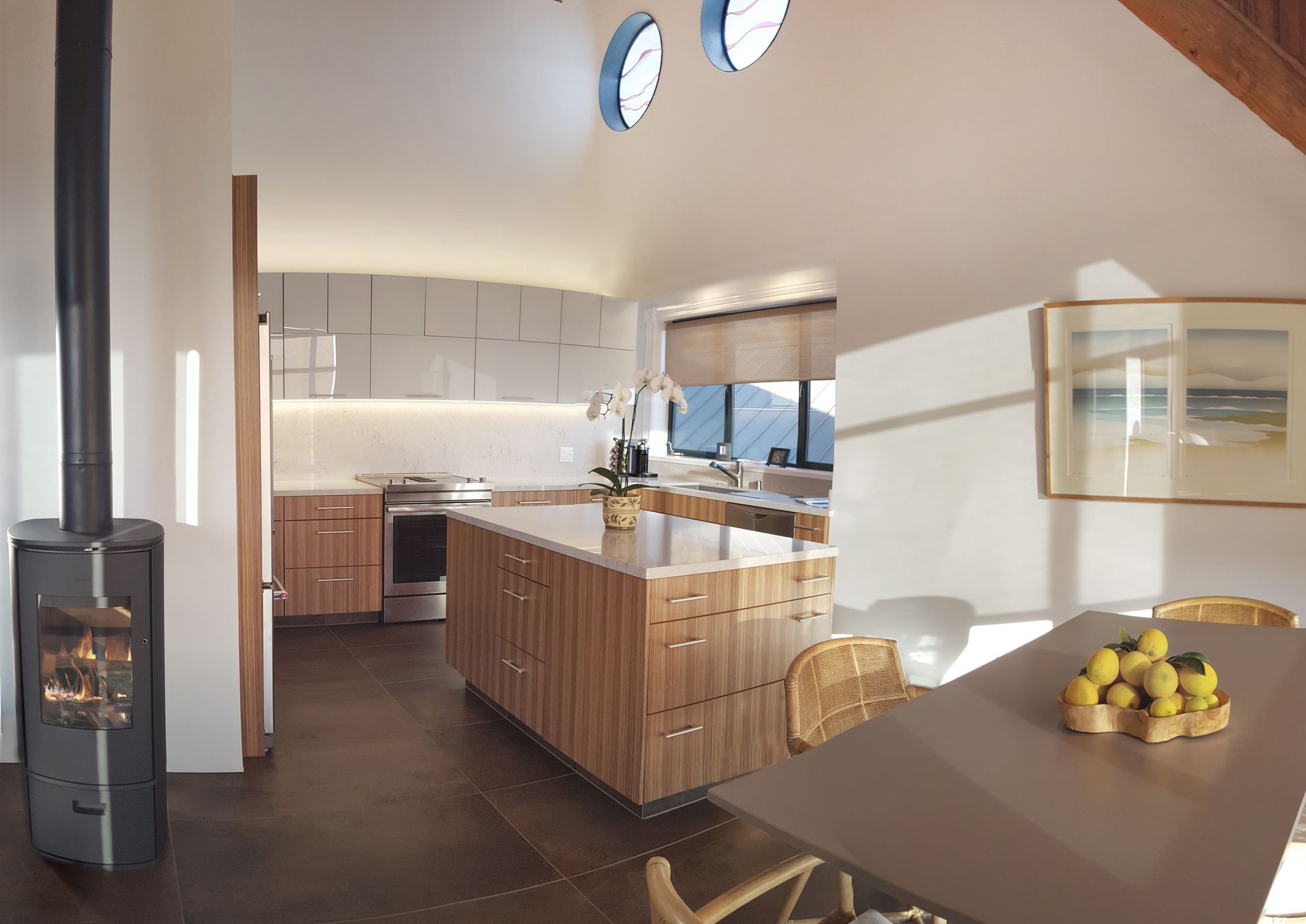 Modern gray kitchen with wooden countertops, built-in appliances, and under-cabinet lighting