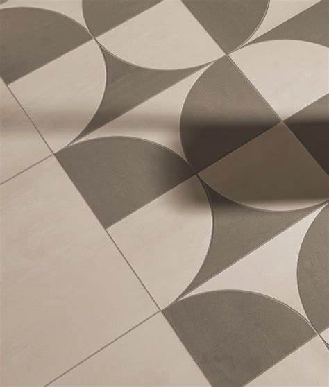 Geometric patterned floor tiles in beige, gray, and brown tones arranged in a diagonal view