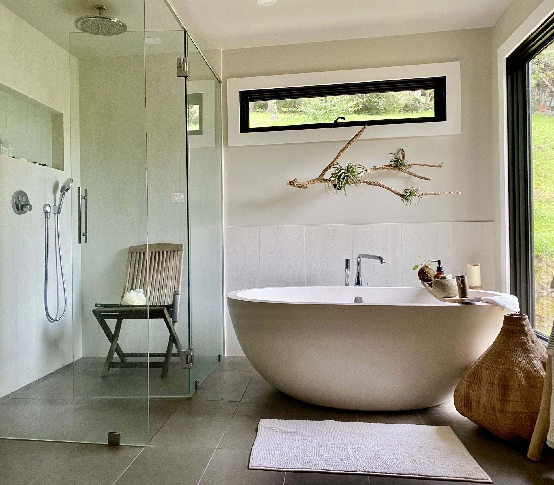 Modern bathroom with freestanding tub, glass shower, and natural wood accents