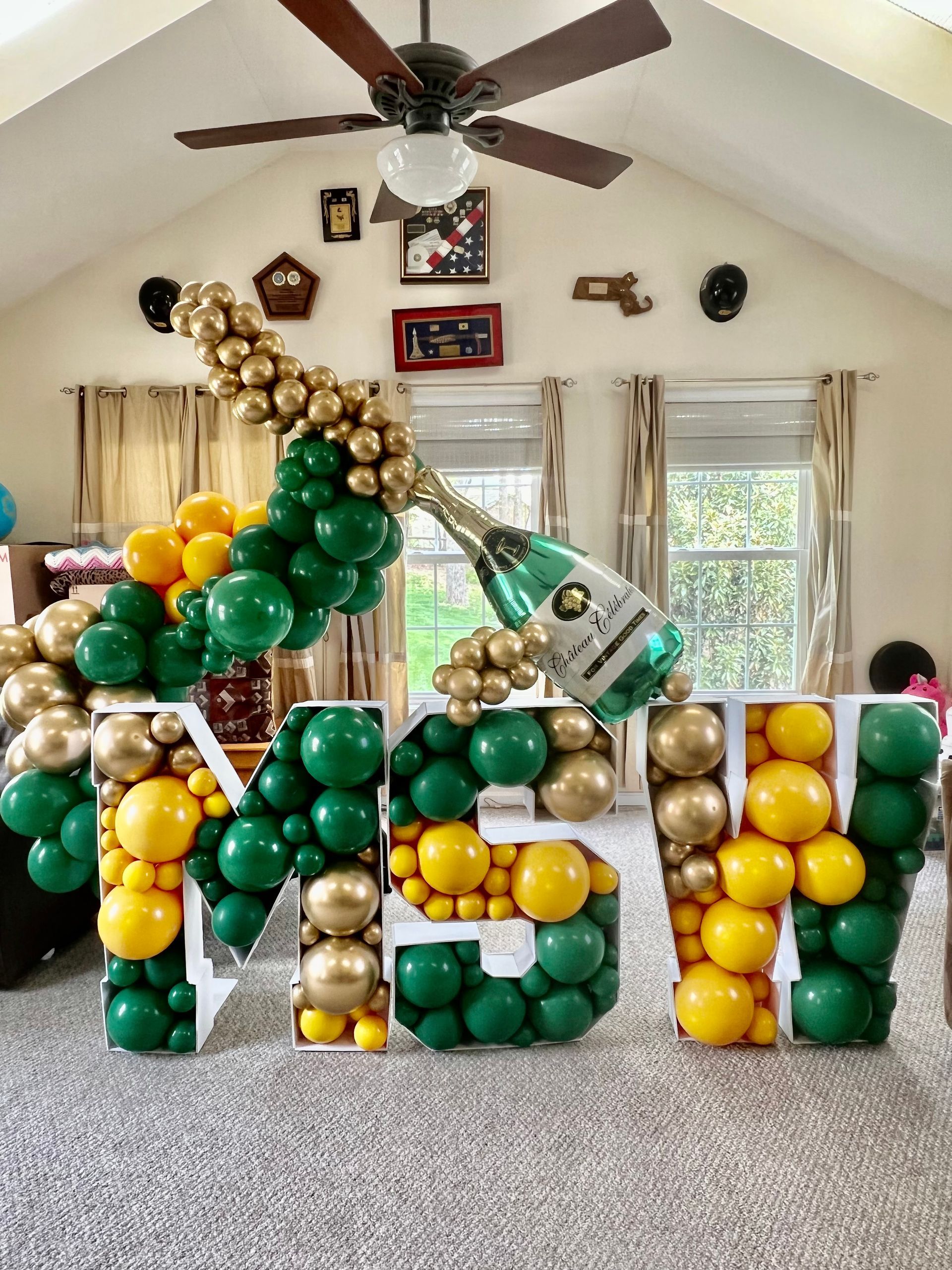 A bottle of champagne is pouring out of a balloon shaped like the word new.