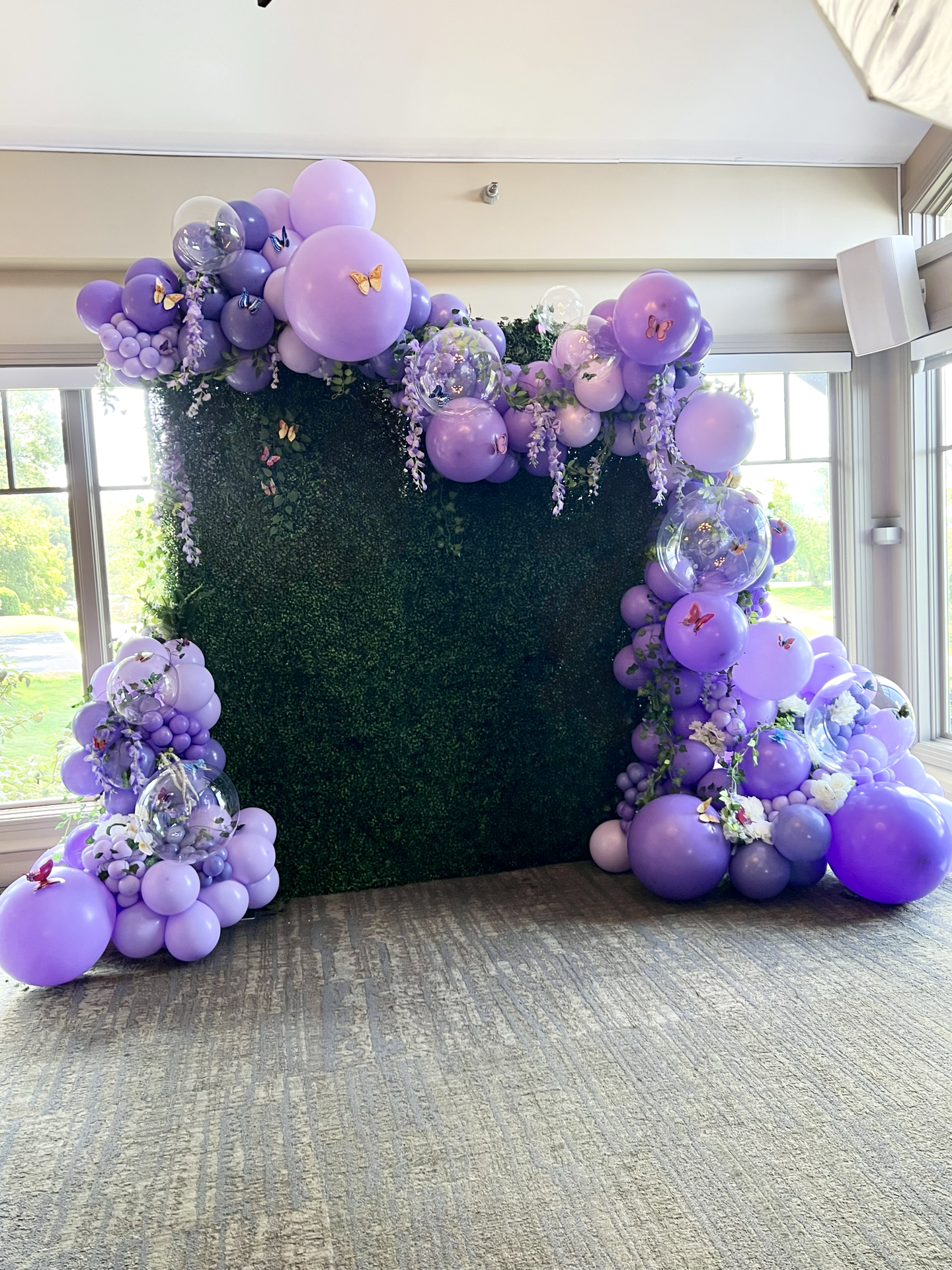 A room filled with purple balloons and flowers.