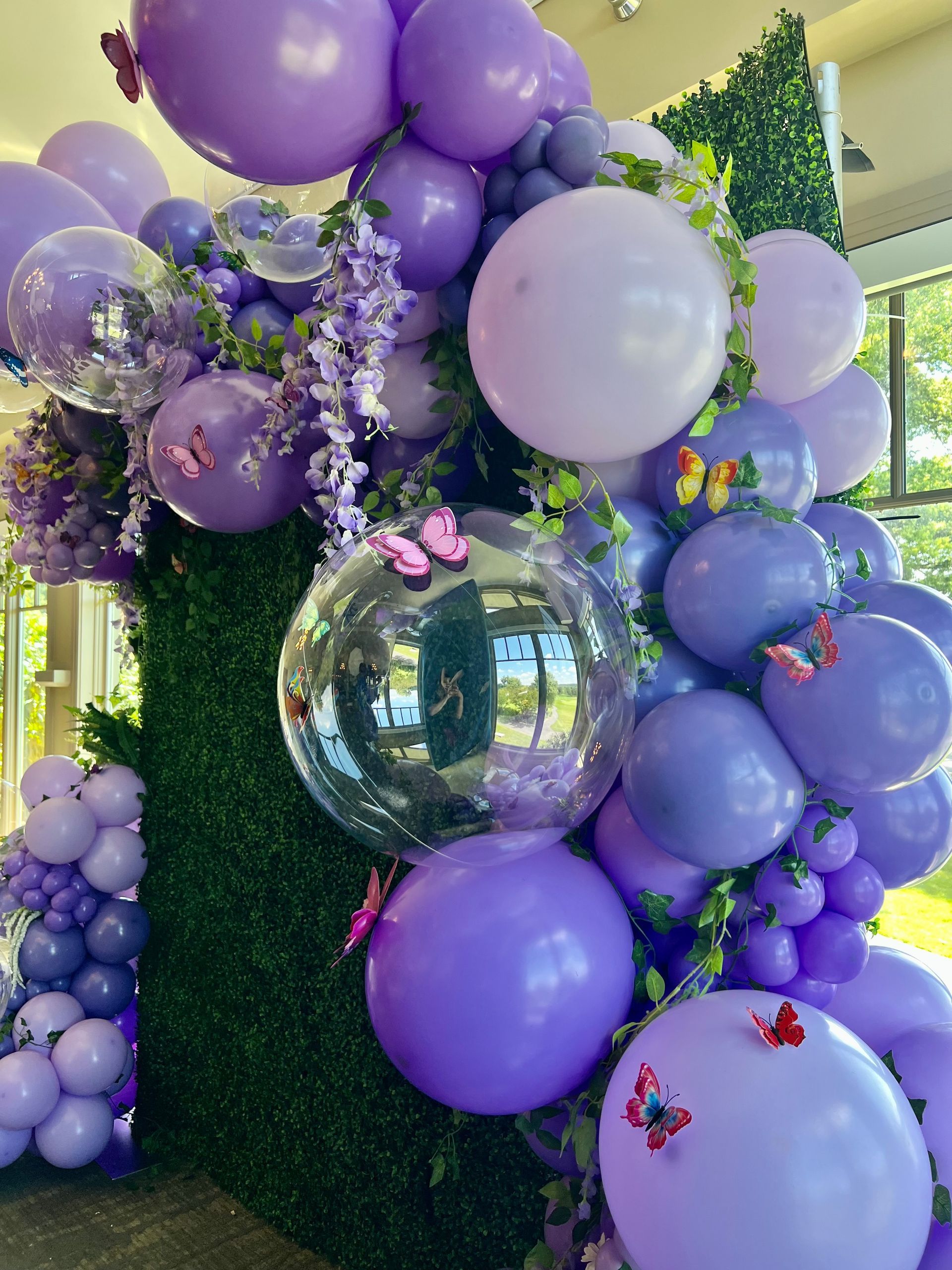 A bunch of purple balloons are sitting on top of each other on a wall.