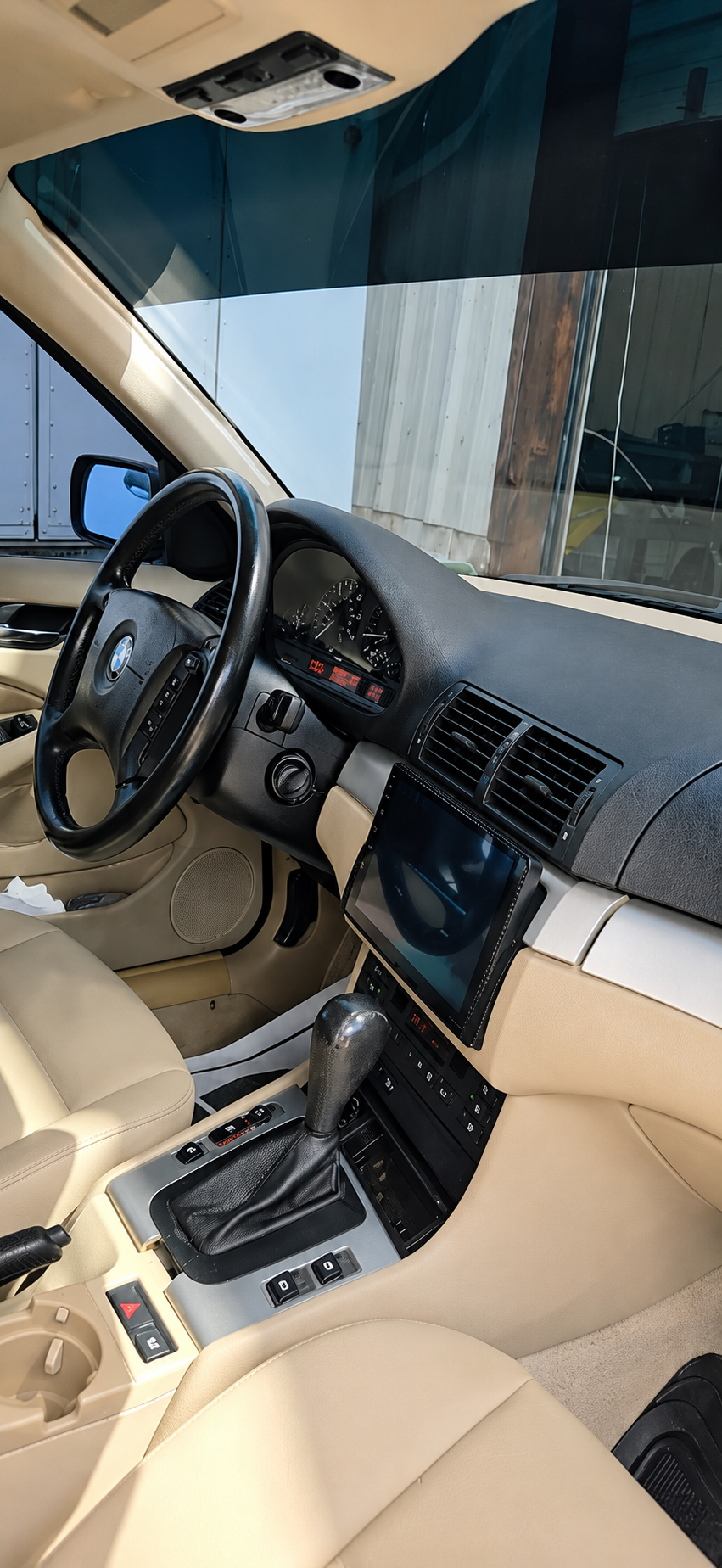 Tan leather car interior with dashboard, steering wheel, center console, and front seats visible