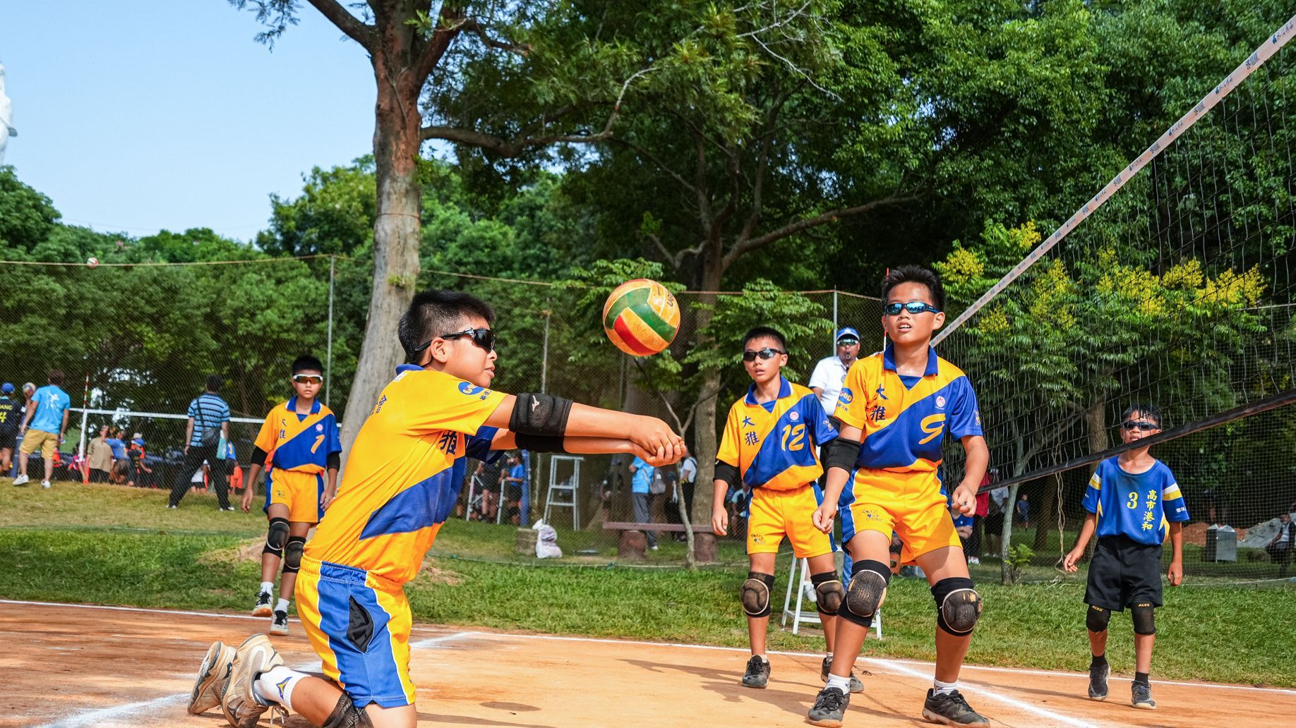 一群小男孩正在公園打排球。