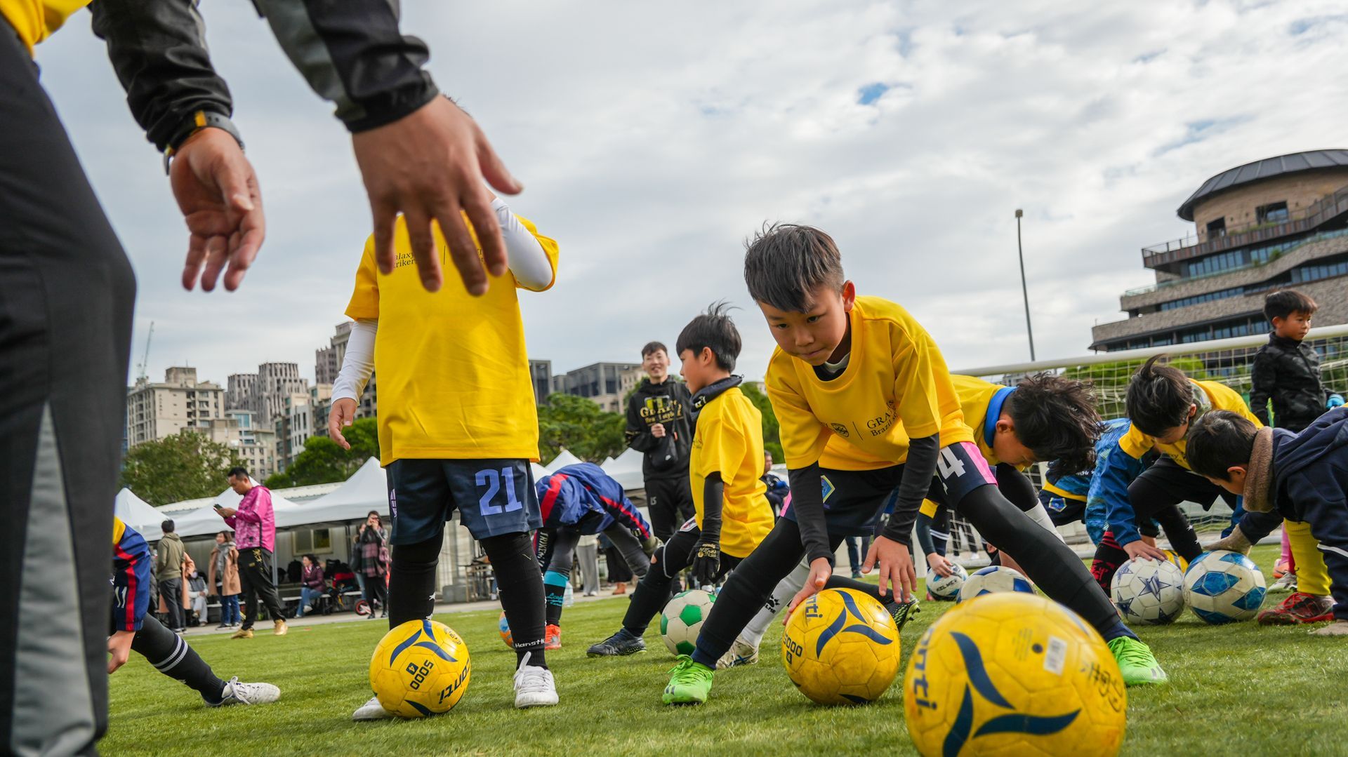 一群小男孩正在球場上踢足球做伸展運動。