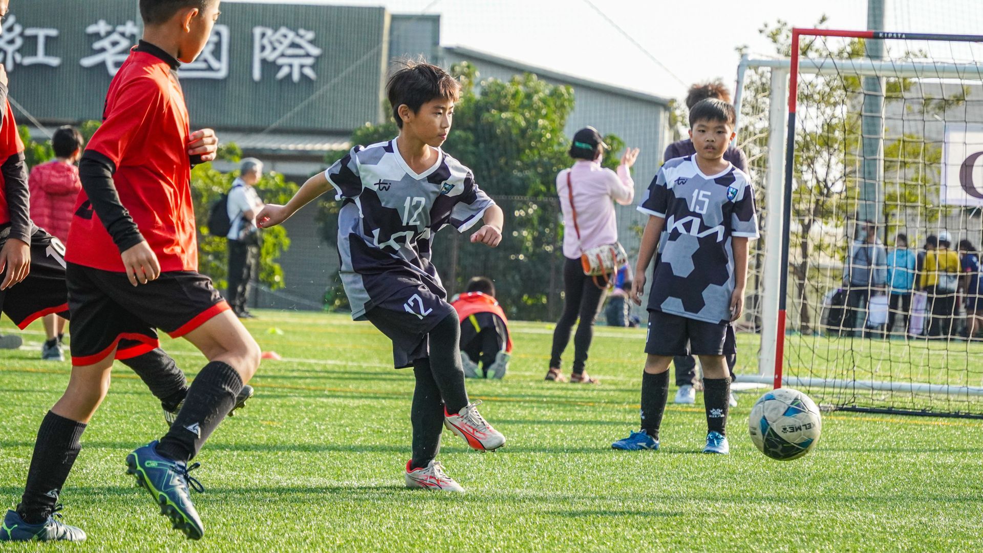 一群小男孩正在操場上踢足球。