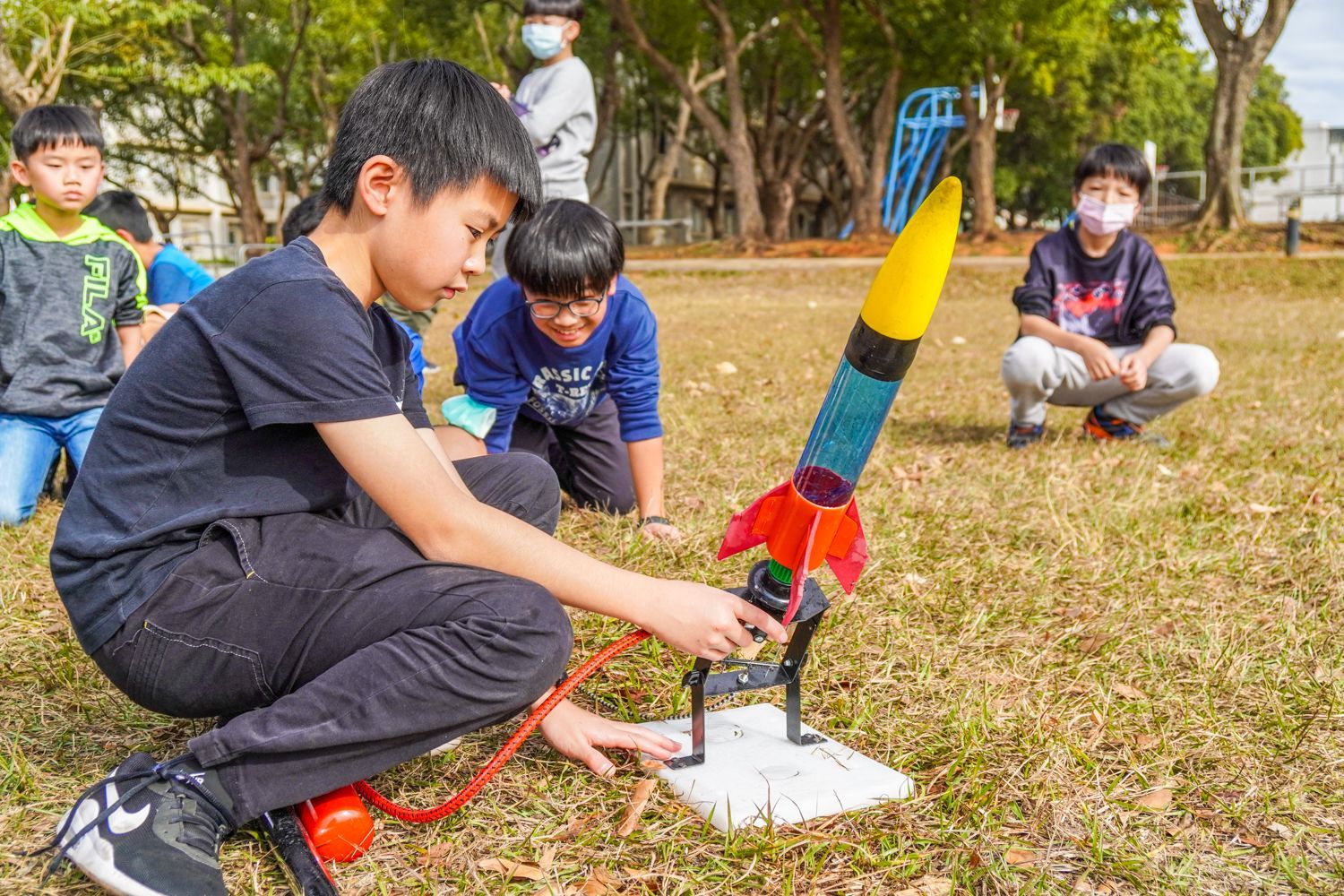 一群孩子正在公園玩火箭。