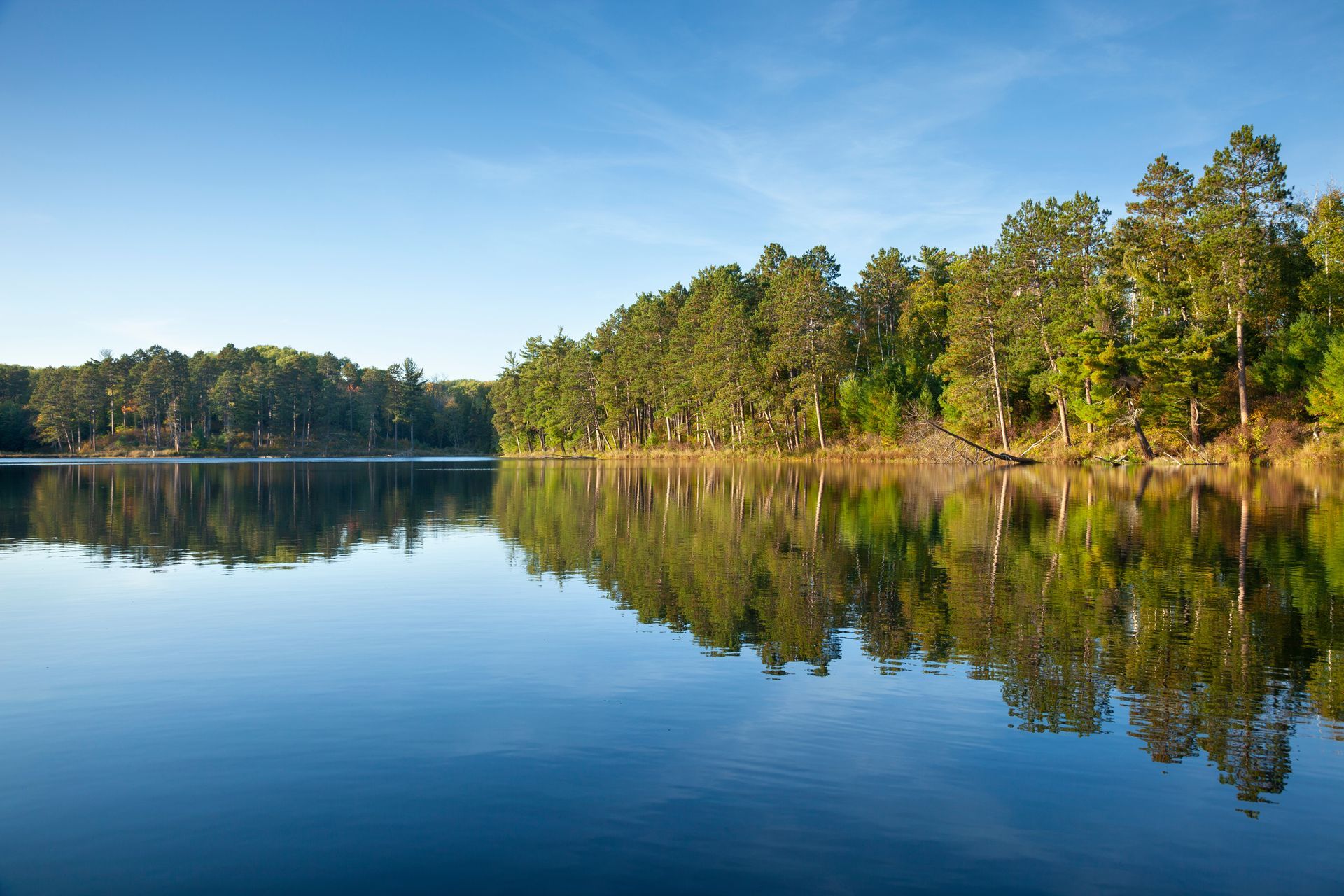 Mountainous landscape with turquoise lake and evergreen trees.