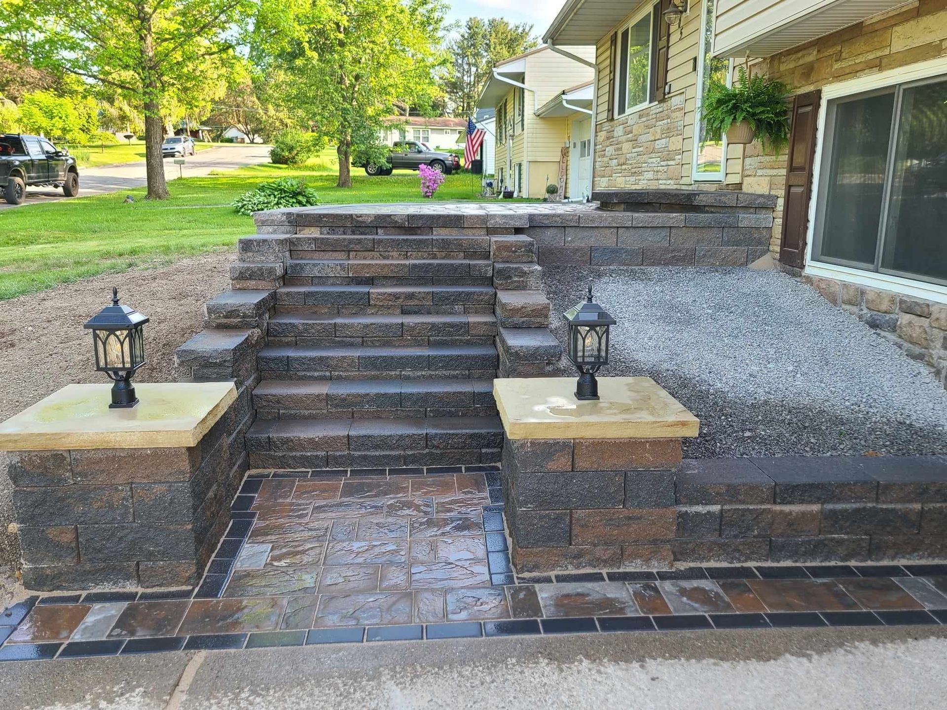 A brick walkway with stairs leading up to a house.