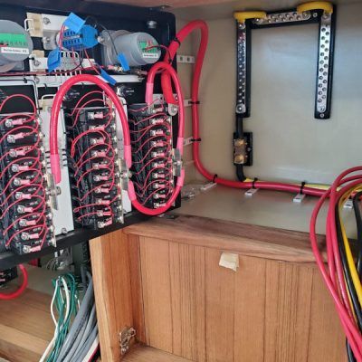 A wooden cabinet with a bunch of wires coming out of it.