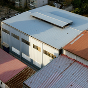 A fire truck with an extended ladder works on the damaged roof of a red brick church under a clear blue sky.
