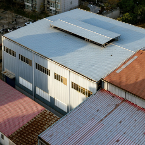 A fire truck with an extended ladder works on the damaged roof of a red brick church under a clear blue sky.