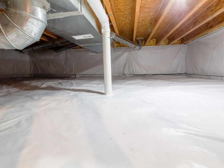 Basement interior with white vapor barrier on floor and walls; exposed beams, ductwork, and a support column.