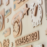 Wooden wall display with decorative clocks and numbers in soft beige tones