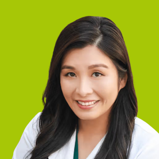 Smiling woman in a white coat against a bright green background