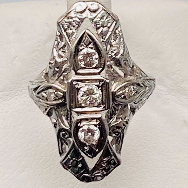 Silver ornate ring with a central clear stone and floral filigree design
