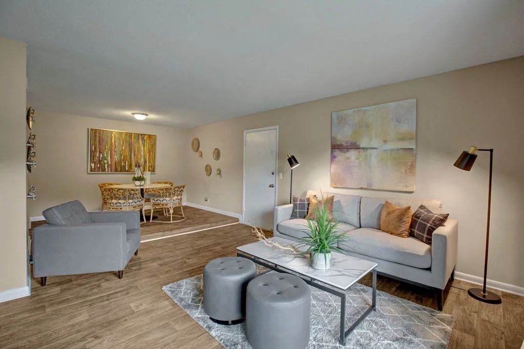 Modern living room with gray sofas, coffee table, floor lamp, and warm beige decor