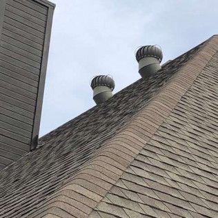 There are two wind turbines on the roof of a building.