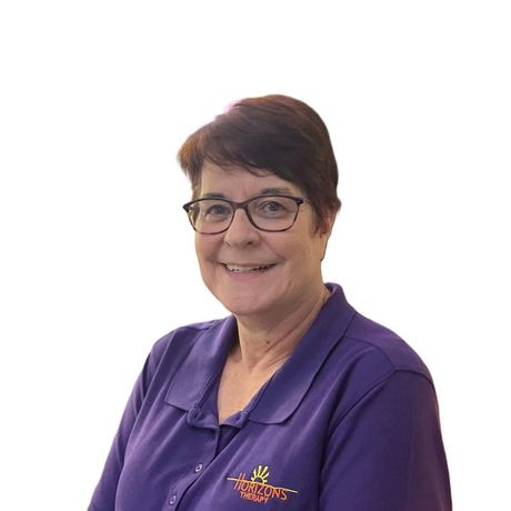 A woman wearing glasses and a black shirt smiles for the camera