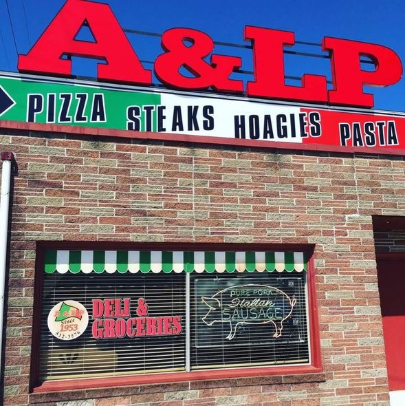 A brick building with a sign that says a&lp pizza, steaks, hoagies, pasta